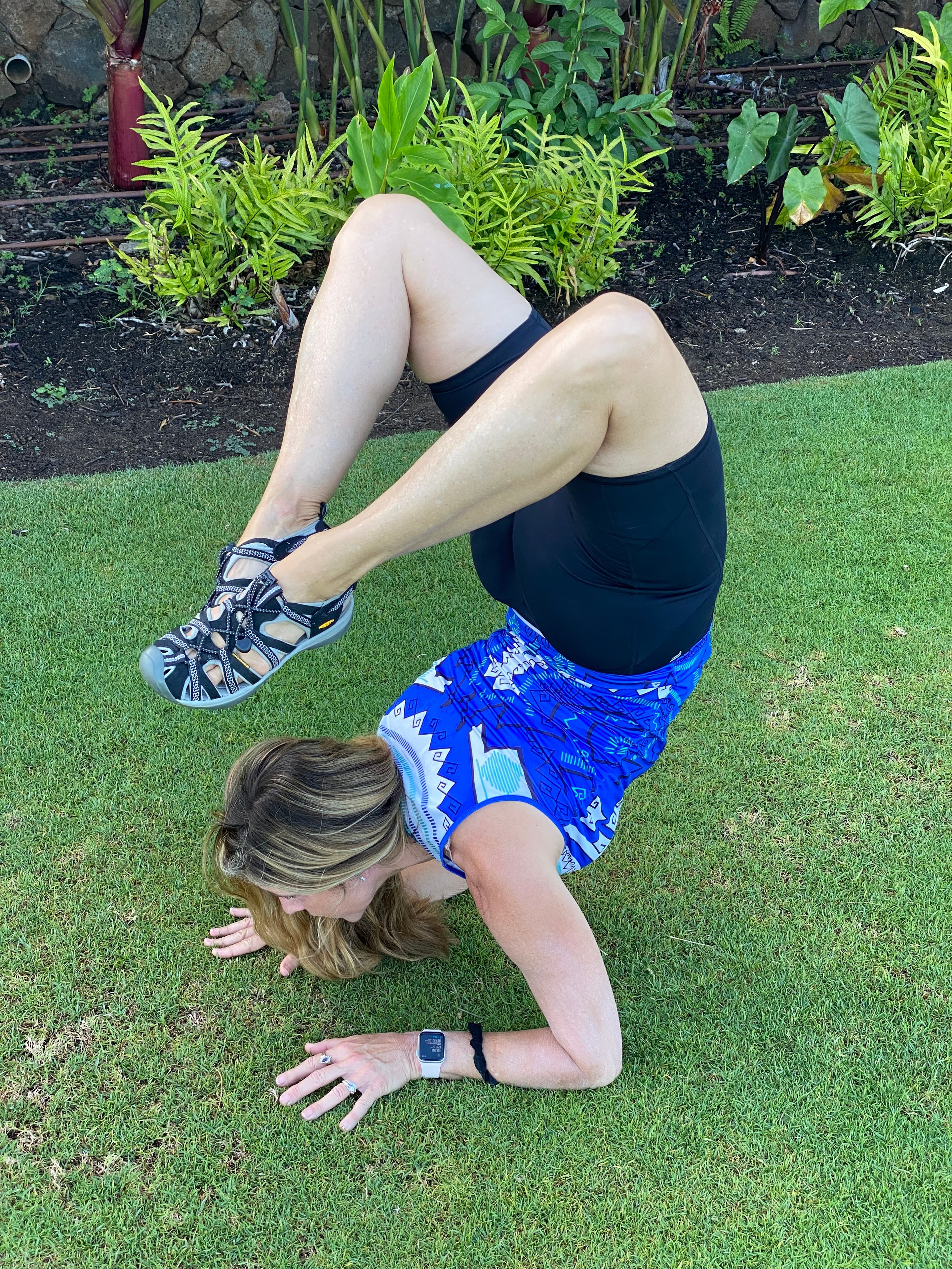 Danette practicing yoga outdoors on grass